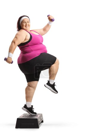 Téléchargez les photos : Femme en surpoids faisant de l'aérobic pas à pas avec des poids isolés sur fond blanc - en image libre de droit