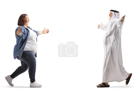 Téléchargez les photos : Femme rencontrant et saluant un homme musulman dans une robe traditionnelle isolée sur fond blanc - en image libre de droit
