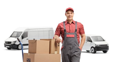 Foto de Trabajador con una furgoneta y una pila de cajas cargadas en un camión de mano aislado sobre fondo blanco - Imagen libre de derechos