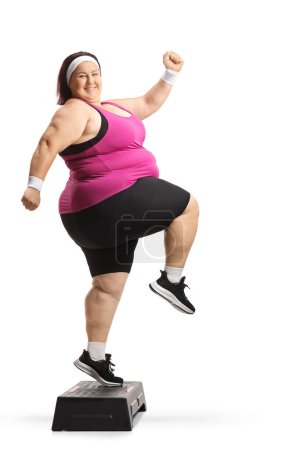Photo for Cheerful overweight woman exercising step aerpbics isolated on white background - Royalty Free Image