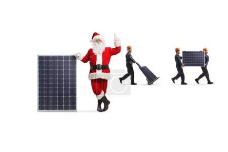 Foto de Santa Claus señalando hacia arriba y los trabajadores de la fábrica llevando células fotovoltaicas aisladas sobre fondo blanco - Imagen libre de derechos