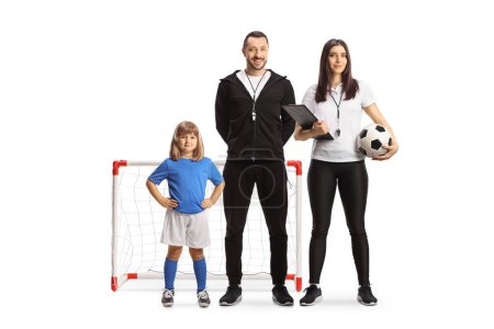 Photo for Little girl with football coaches standing in front of a mini goal isolated on white background - Royalty Free Image