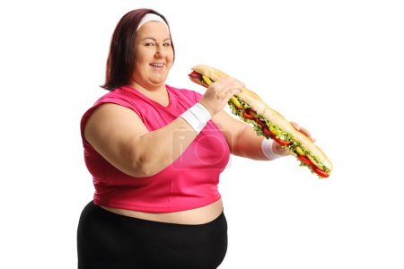Photo for Happy chubby woman in sportswear holding a big sandwich isolated on white background - Royalty Free Image