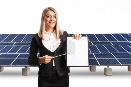 Photo for Businesswoman smiling and presenting a document in front of photovoltaics isolated on white background - Royalty Free Image