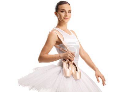 Téléchargez les photos : Ballet danseuse tenant ses chaussures d'orteil et souriant isolé sur fond blanc - en image libre de droit