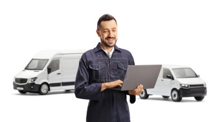 Photo for Auto mechanic using a laptop computer in front of vans isolated on white background - Royalty Free Image