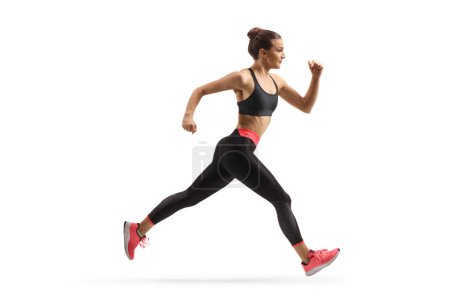 Foto de Foto de perfil de longitud completa de una joven en forma corriendo aislada sobre fondo blanco - Imagen libre de derechos