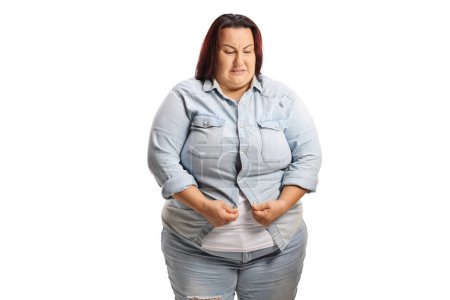 Photo for Overweight woman trying to squeeze into a denim shirt isolated on white background - Royalty Free Image