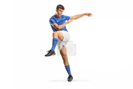 Foto de Joven futbolista en una pose de patada aislado sobre fondo blanco - Imagen libre de derechos