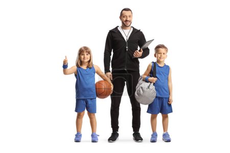 Foto de Entrenador de baloncesto de pie con un niño y una niña en camisetas deportivas aislados en el fondo blanco - Imagen libre de derechos