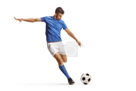 Foto de Jugador de fútbol en un top de jersey azul corriendo y preparándose para patear una pelota aislada sobre fondo blanco - Imagen libre de derechos