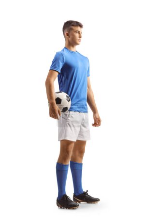 Foto de Jugador de fútbol en un top azul y pantalones cortos blancos sosteniendo una pelota aislada sobre fondo blanco - Imagen libre de derechos