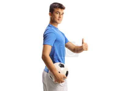 Photo for Young football player holding a ball and gesturing thumbs up isolated on white background - Royalty Free Image