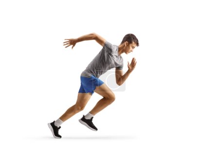 Foto de Imagen de perfil completo de un joven en forma que corre rápido aislado sobre fondo blanco - Imagen libre de derechos