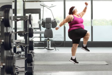 Photo for Full length profile shot of a young overweight woman exercising in a gym - Royalty Free Image