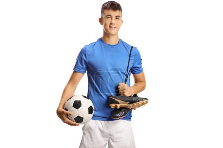 Foto de Joven futbolista sosteniendo una pelota y tacos aislados sobre fondo blanco - Imagen libre de derechos