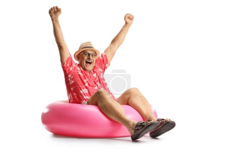 Photo for Mature man sitting on a big swimming rubber ring and gesturing happiness isolated on white background - Royalty Free Image