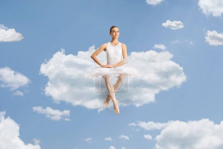 Téléchargez les photos : Belle ballerine assise sur un nuage dans le ciel - en image libre de droit