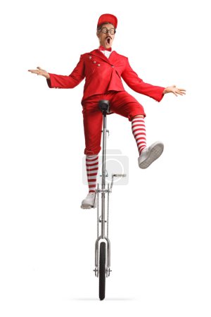 Photo for Entertainer in a red suit riding a tall unicycle isolated on white background - Royalty Free Image