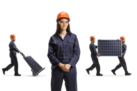 Photo for Female factory worker posing in the front and men carrying photovoltaics isolated on blue background - Royalty Free Image