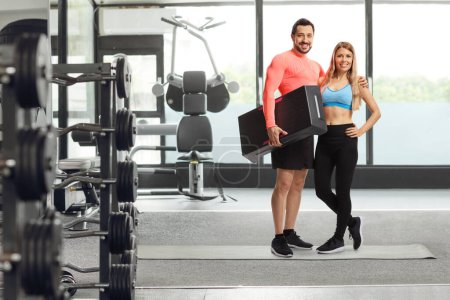 Téléchargez les photos : Portrait complet d'un couple posant dans une salle de gym - en image libre de droit