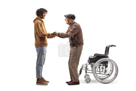 Foto de Joven afroamericano ayudando a un anciano con una silla de ruedas aislada sobre fondo blanco - Imagen libre de derechos