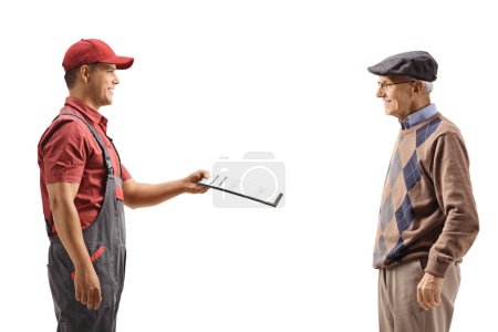 Photo for Profile shot of a male courier handing a document to an elderly gentleman isolated on white background - Royalty Free Image