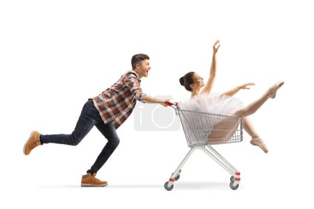 Téléchargez les photos : Un type court et pousse une ballerine dans un caddie isolé sur fond blanc - en image libre de droit