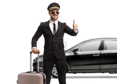 Foto de Chauffeur con una maleta delante de un coche negro haciendo un gesto de un pulgar hacia arriba signo aislado sobre fondo blanco - Imagen libre de derechos