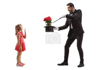 Foto de Perfil de longitud completa de una chica viendo a un mago realizando un truco aislado en el fondo blanco - Imagen libre de derechos