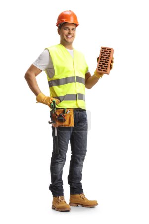 Photo for Smiling construction worker holding a brick isolated on white background - Royalty Free Image