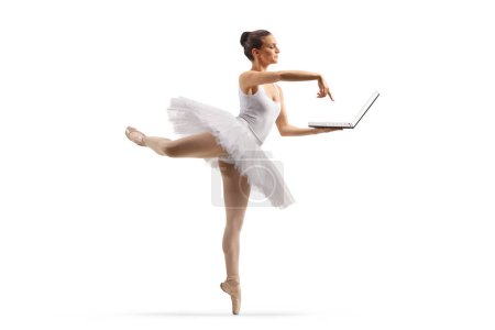 Téléchargez les photos : Plan complet d'une ballerine dansant et utilisant un ordinateur portable isolé sur fond blanc - en image libre de droit