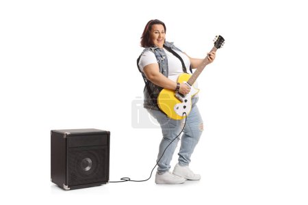 Téléchargez les photos : Corpulent jeune femelle avec une guitare électrique et amplificateur isolé sur fond blanc - en image libre de droit