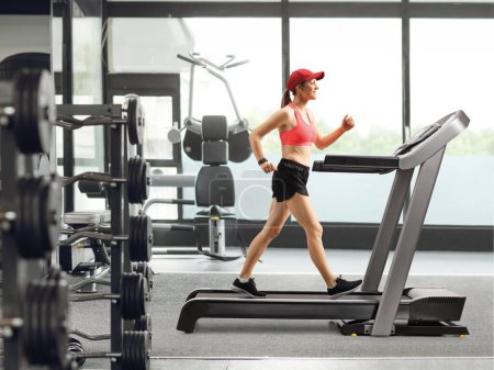 Photo for Full length profile shot of a female exercising on a treadmill at the gym - Royalty Free Image