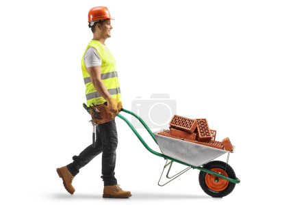 Photo for Construction worker pushing a wheelbarrow with bricks isolated on white background - Royalty Free Image