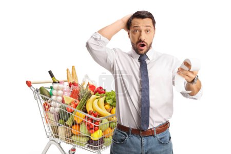Photo for Man with a shopping cart holding a shockingly expensive bill isolated on white background - Royalty Free Image
