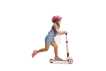 Téléchargez les photos : Plan complet d'une fille avec casque chevauchant un scooter rose isolé sur fond blanc - en image libre de droit