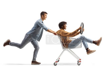 Photo for African american and caucasian male friends riding with a shopping cart isolated on white background - Royalty Free Image