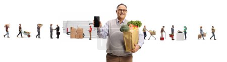 Photo for Mature man with a grocery bag showing a smartphone in front of farmers and customers isolated on white background - Royalty Free Image