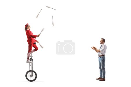 Téléchargez les photos : Homme applaudissant un acrobate chevauchant une girafe monocycle et jonglant isolé sur fond blanc - en image libre de droit