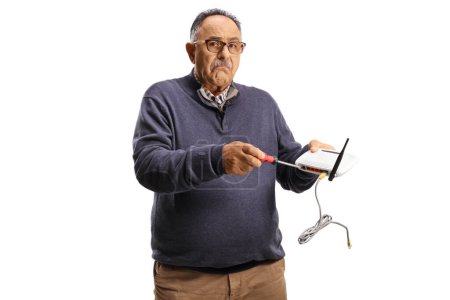 Photo for Confused mature man fixing router with a screwdriver isolated on white background - Royalty Free Image