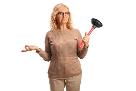 Photo for Confused mature woman holding a toiler plunger isolated on white background - Royalty Free Image