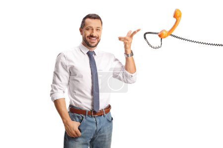 Photo for Happy professional man throwing a rotary phone with a cable isolated on white background - Royalty Free Image
