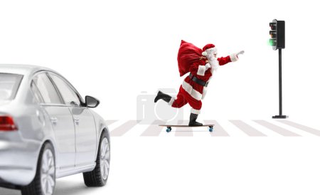Photo for Full length profile shot of Santa Claus riding a longboard across a pedestrian crossing isolated on white background - Royalty Free Image