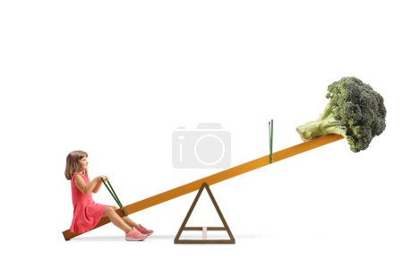 Photo for Little girl sitting on a seesaw with broccoli, healthy diet concept, isolated on white background - Royalty Free Image