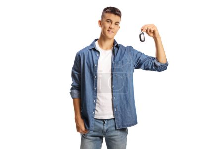 Foto de Hombre adolescente sosteniendo una llave de coche y sonriendo aislado sobre fondo blanco - Imagen libre de derechos