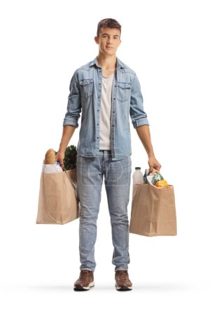 Photo for Full length portrait of a male teenager holding grocery bags isolated on white background - Royalty Free Image