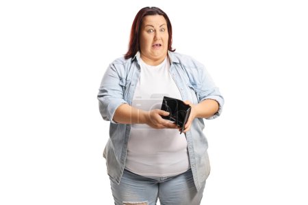 Téléchargez les photos : Femme corpulente choquée tenant un portefeuille vide isolé sur fond blanc - en image libre de droit