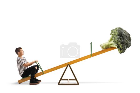 Photo for Boy and a broccoli vegetable on a seesaw isolated on white background - Royalty Free Image