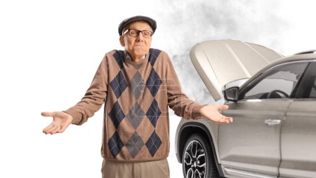 Téléchargez les photos : Homme âgé confus debout devant une voiture cassée isolée sur fond blanc - en image libre de droit